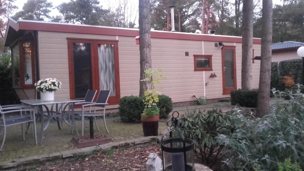 a small pink cabin with a table and chairs at Jachtslot Chalet J8 in Doornspijk