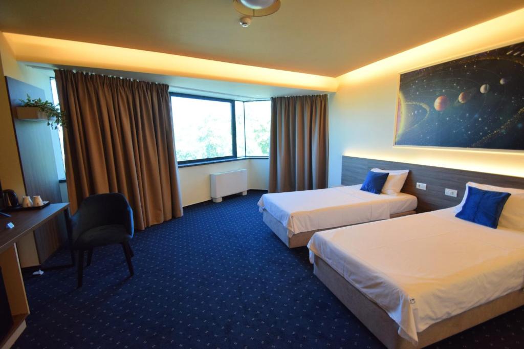 ein Hotelzimmer mit zwei Betten und einem Schreibtisch in der Unterkunft Kepler Residence in Bukarest