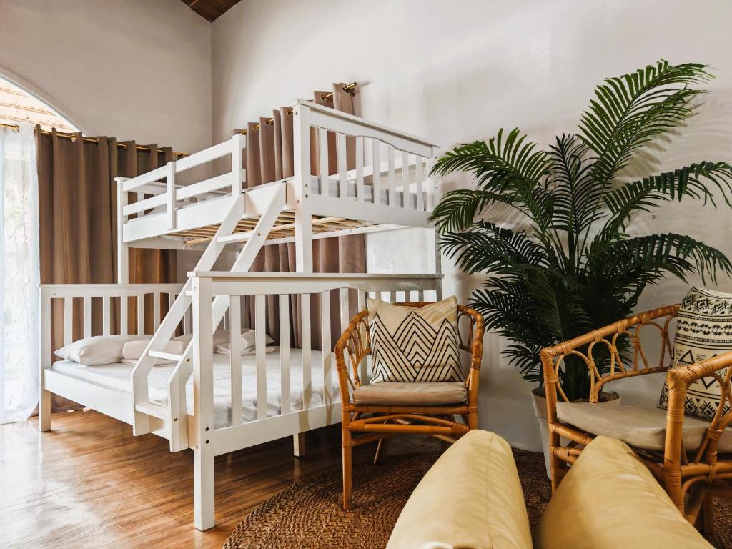 a white bunk bed in a living room with a plant at Manawari Beach Resort in Caliclic