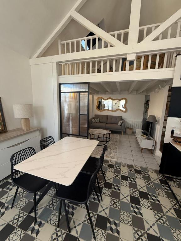 a dining room with a white table and chairs at Maison aux portes de la Sologne in Marcilly-en-Villette