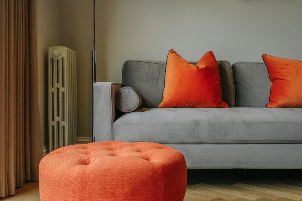 a living room with a couch with orange pillows at Elegant 2-Bed Luxury Apartment - Prime Location in Bristol
