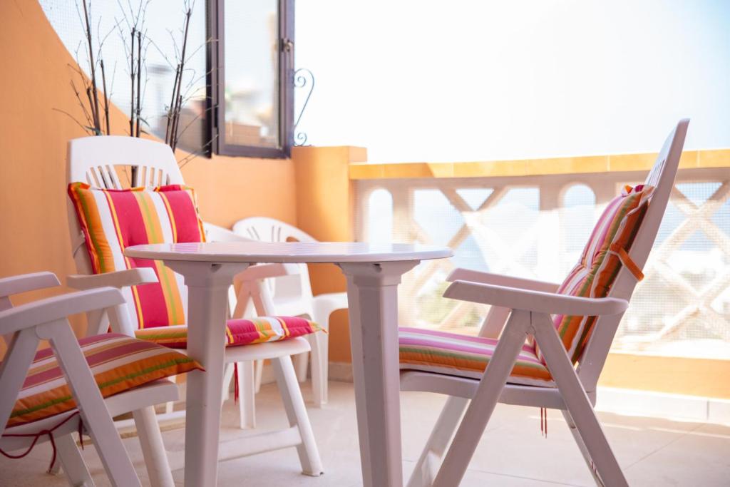 een tafel en stoelen in een kamer met een raam bij Ocean view OR426 in Adeje