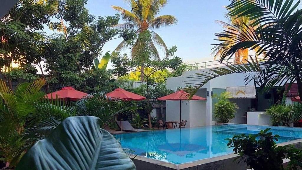 Phumĭ Ta PhŭlにあるRachna Mutita Residenceのヤシの木のあるリゾートのプール
