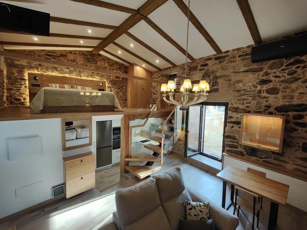 un salon avec un canapé et un mur en pierre dans l'établissement A Casa de Salvador - retiro rural con alma gallega, à Vedra