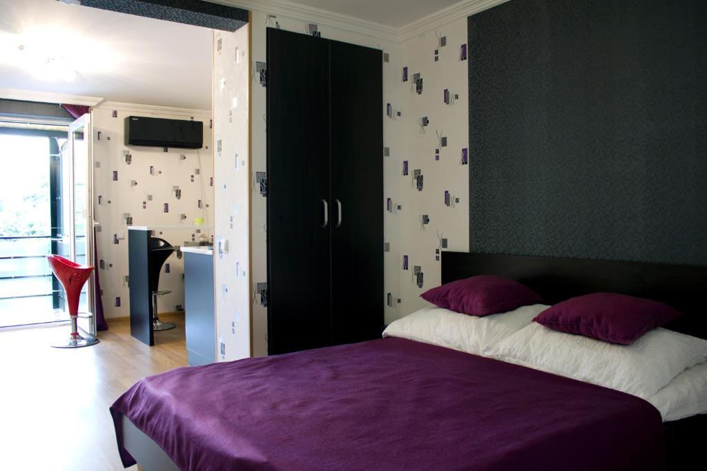 a bedroom with a bed with a purple comforter at Hotel Your Comfort in Tbilisi City