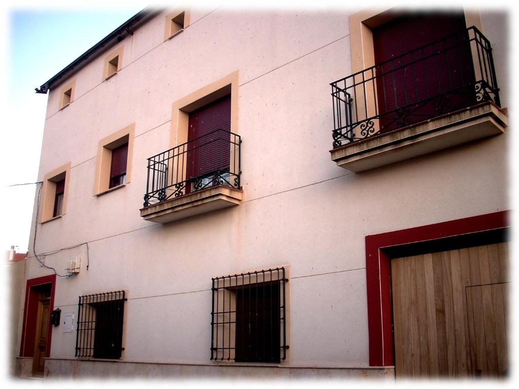 een wit gebouw met ramen en balkons bij Centro Ornitológico El Primillar in Cañada de Calatrava