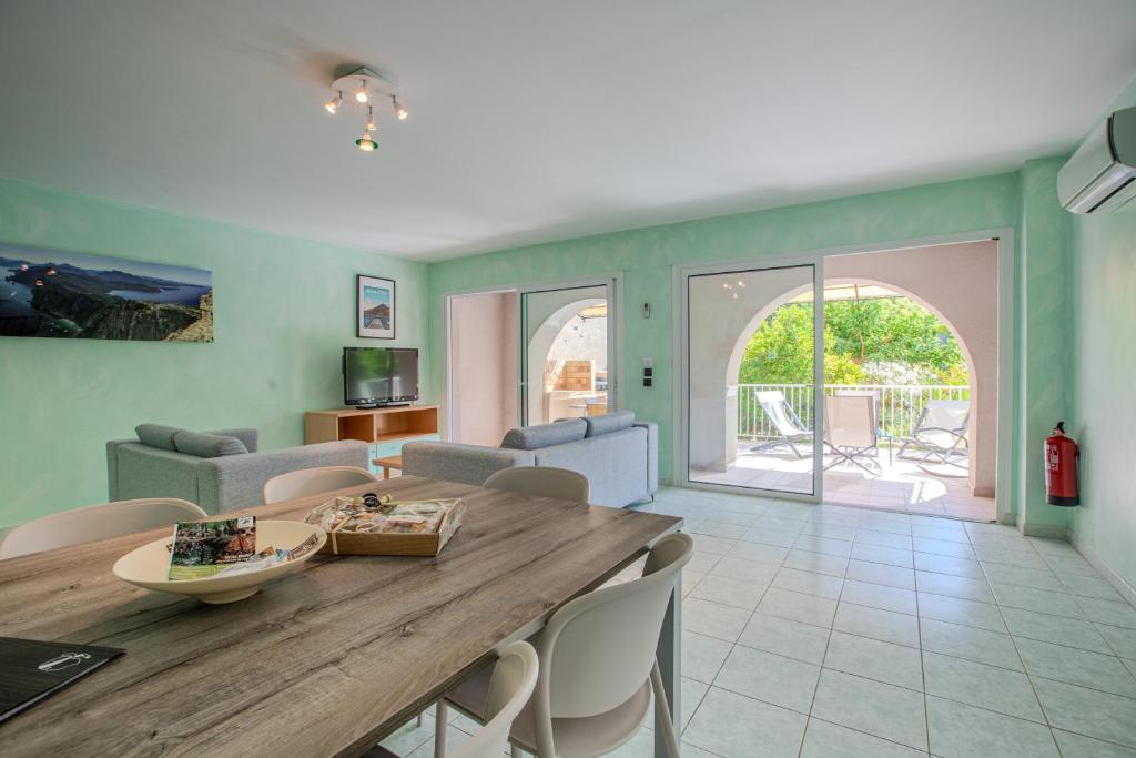 un salon avec une table et des chaises en bois dans l'établissement Les Villas Maristella, Villa Ninu, à Aregno