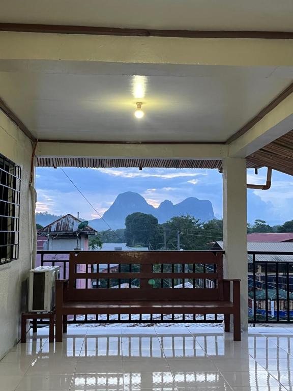 a balcony with a bench and a view of mountains at Casa Huway in El Nido