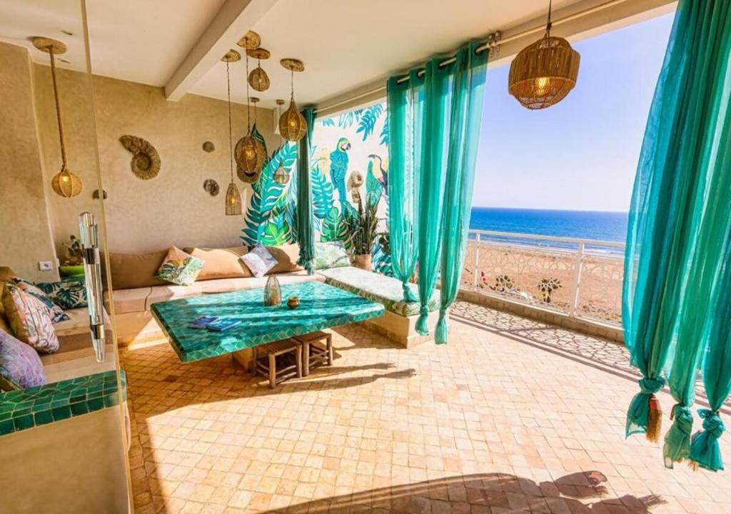 ein Wohnzimmer mit Couch und Blick aufs Meer in der Unterkunft Dar Mogador Océan near Taghazout - Surf, colorful village in Taghazout