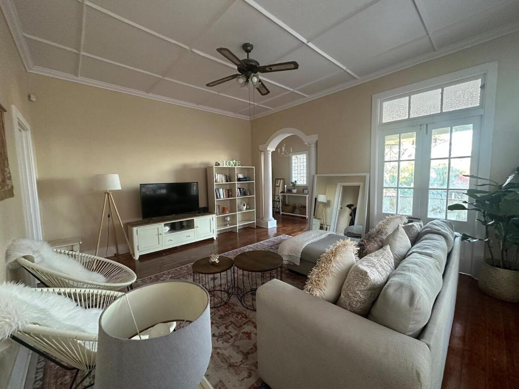 a living room with a couch and a tv at Glenwood Cottage 5km from beach, Art gallery, with garden and pool in Durban