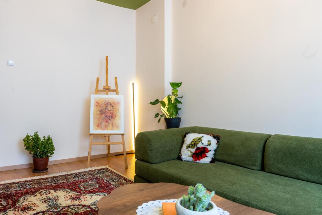 a living room with a green couch and a table at Grape Apartment Studio in Rahovec