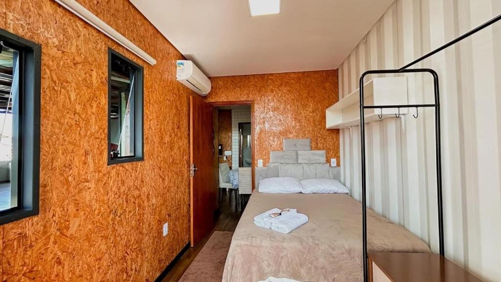 two beds in a room with orange walls at Loft pertinho do Aeroporto de Navegantes! in Navegantes