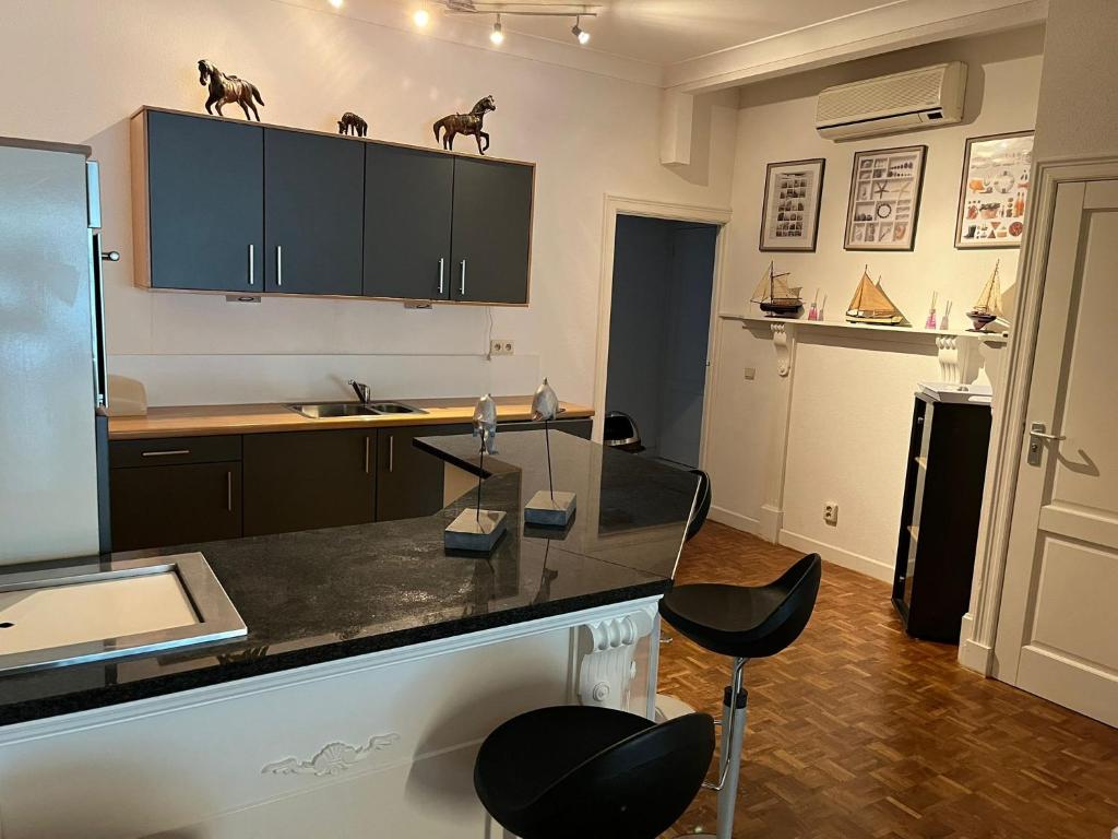 een keuken met een aanrecht en een aantal zwarte stoelen bij Sea Dream in Oostende