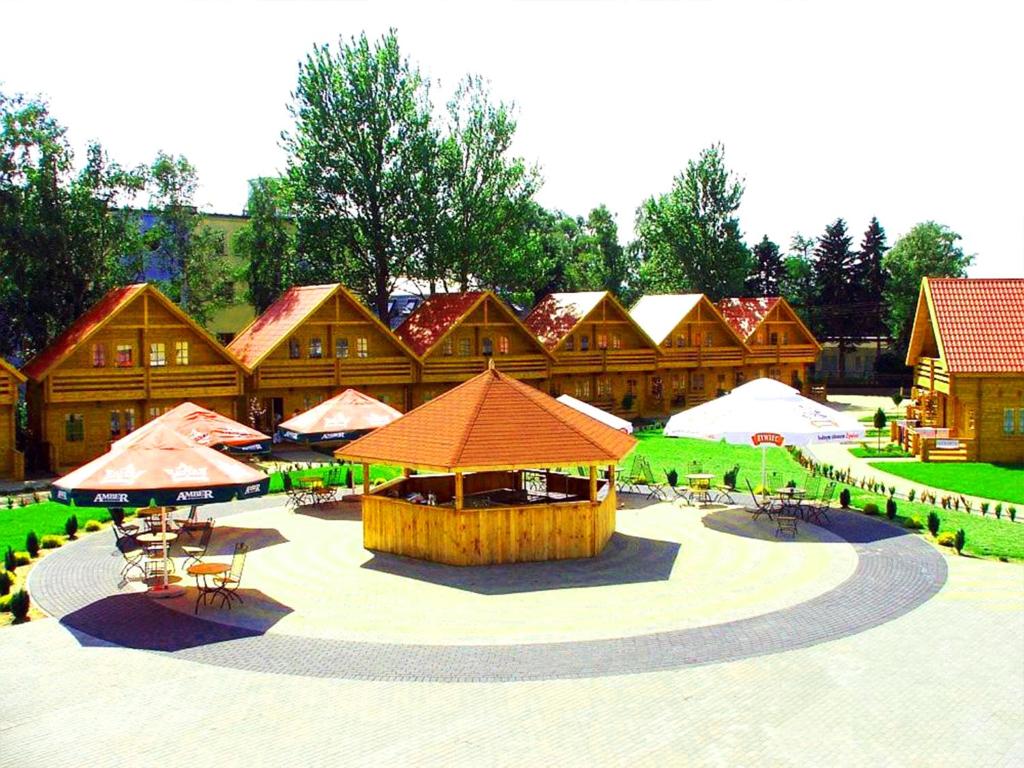 a building with a patio with tables and umbrellas at Neptun Ψ Domki - Jastrzębia Góra Centrum in Władysławowo