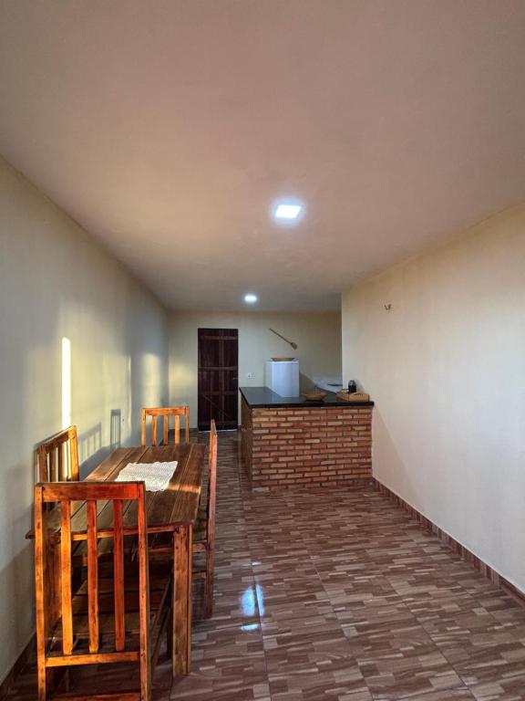 ein Esszimmer mit einem Tisch, Stühlen und einer Theke in der Unterkunft Chalé Levi BG in Barrinha