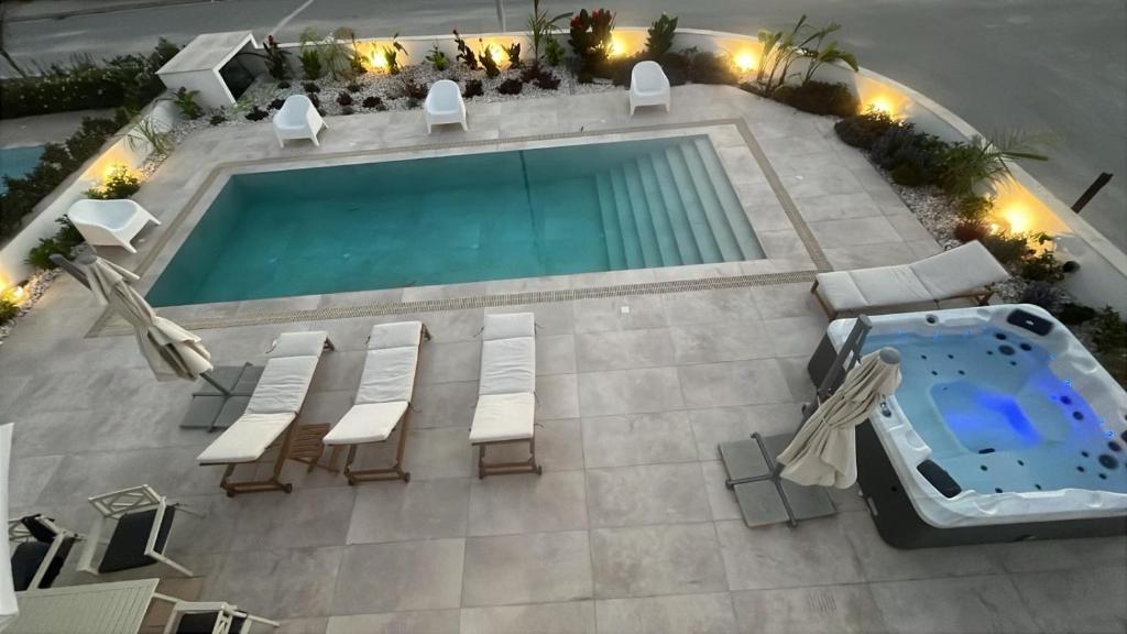 una vista sul tetto di una piscina con sedie e tavolo di Nadine sea side villas a Larnaka