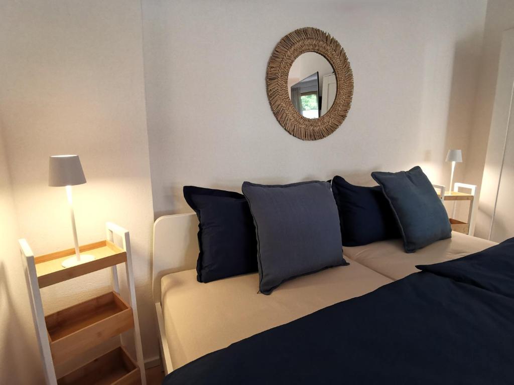 a bedroom with a bed with blue pillows and a mirror at Ferienwohnung Am Hunnenbrunnen in Güntersleben