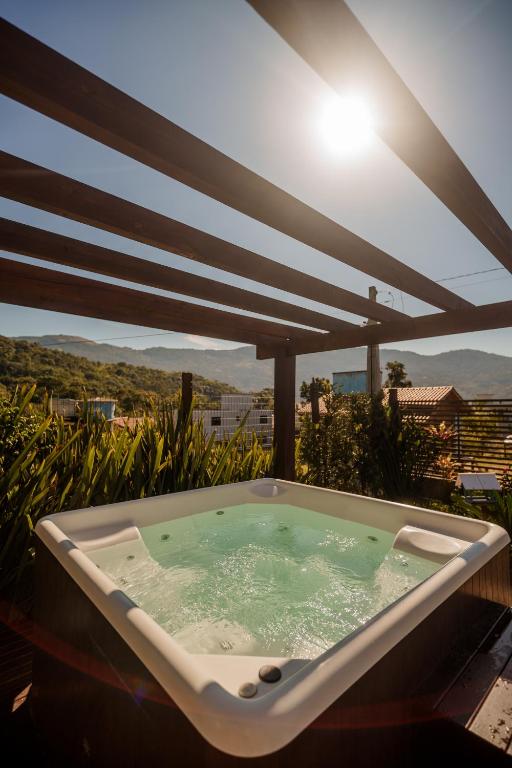 a jacuzzi tub sitting on top of a balcony at Dunas Studios in Garopaba