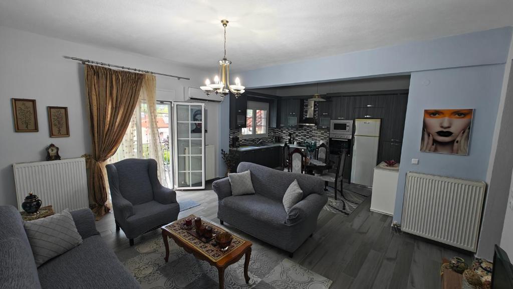a living room with a couch and chairs and a kitchen at Apartment with Mountain View in Kato Loutraki
