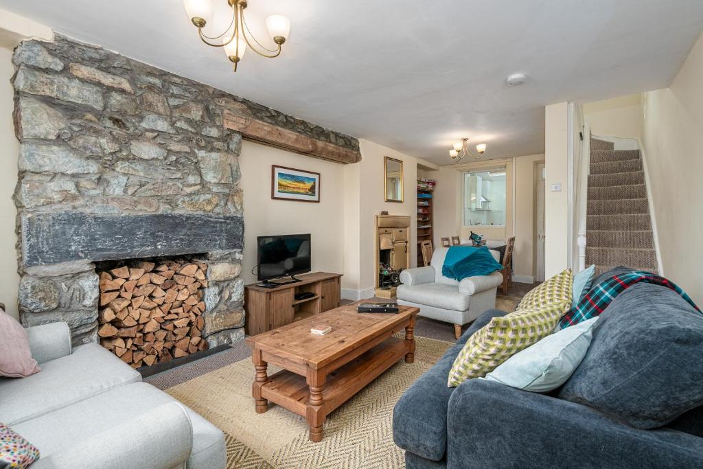 a living room with a stone fireplace and a couch at Glasfryn Cottage Dolgellau in Dolgellau