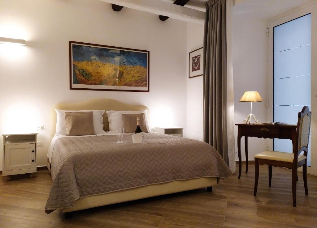 a bedroom with a bed and a table and a desk at Perca39 Casa nel cuore di Napoli, zona Sanità in Naples