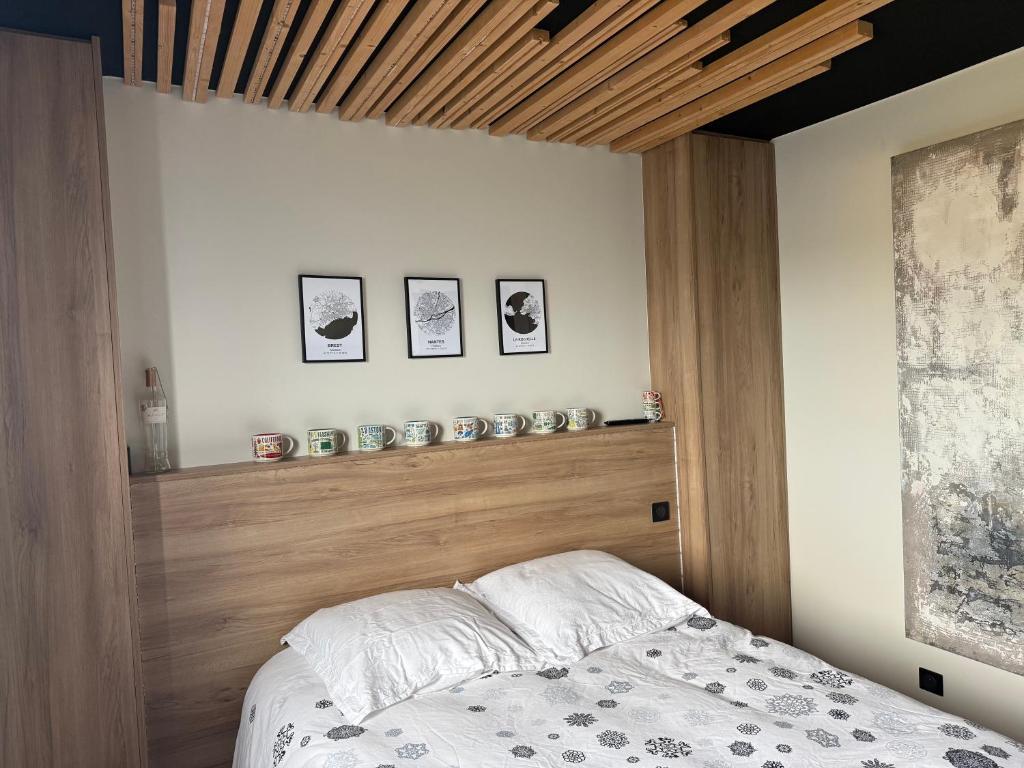 a bedroom with a bed with a wooden head board at Chambre d'hôte à Sieck in Santec