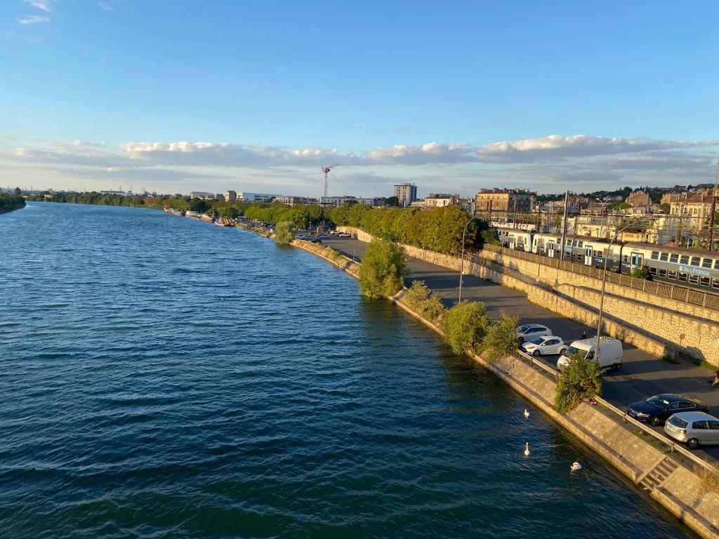 a river with cars parked on the side of it at Studio 50 M2 15MN de Paris in Villeneuve-le-Roi