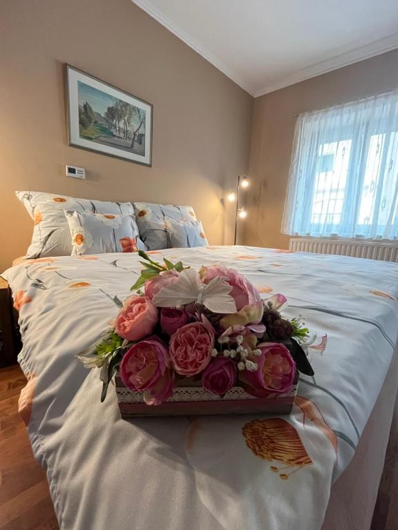a tray of roses on a bed in a bedroom at Tessa Central House in Kőszeg