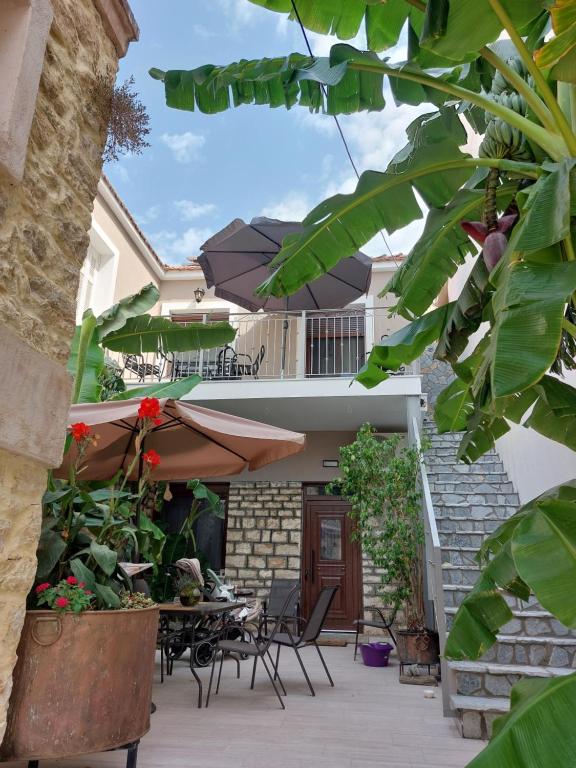 a patio with a table and chairs and an umbrella at Stone-built Villa Nesseris 80 m2 in Preveza