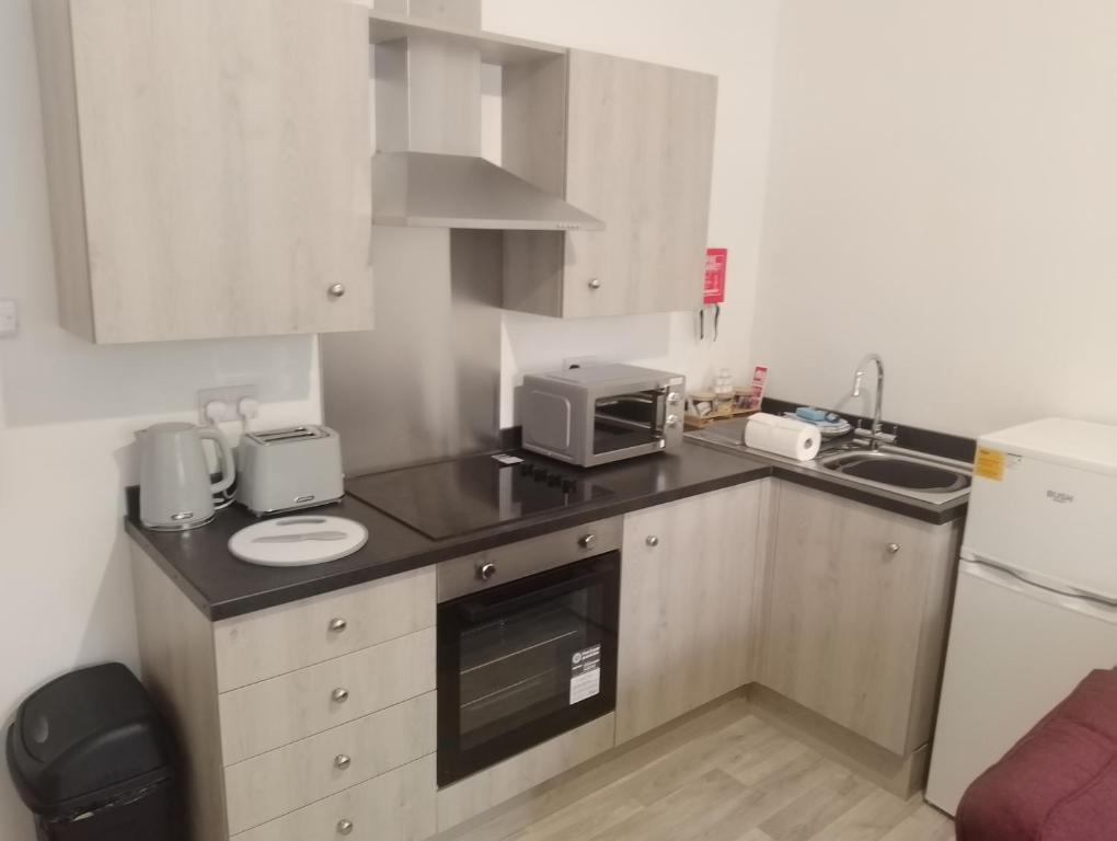 a small kitchen with a sink and a microwave at Coach House Apartment - Sleeps 2 in Whitehaven