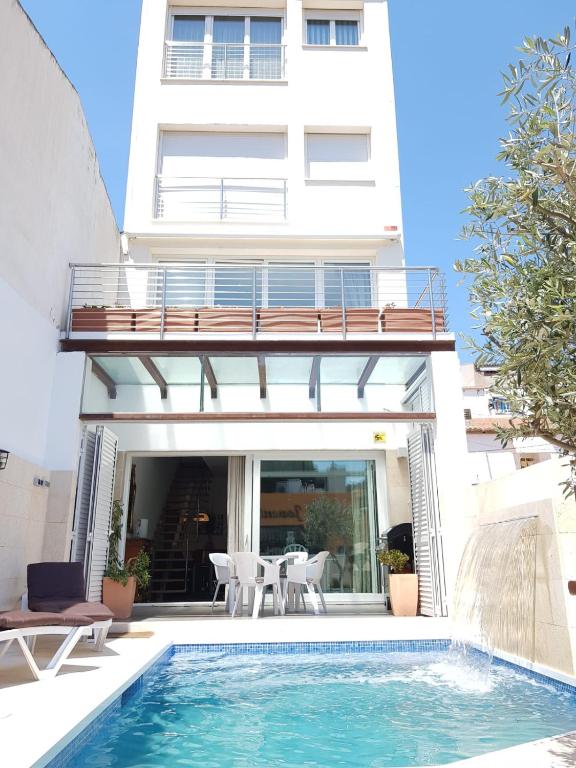 a villa with a swimming pool in front of a building at Villa Mon Repos Bed & Breakfast in Colera