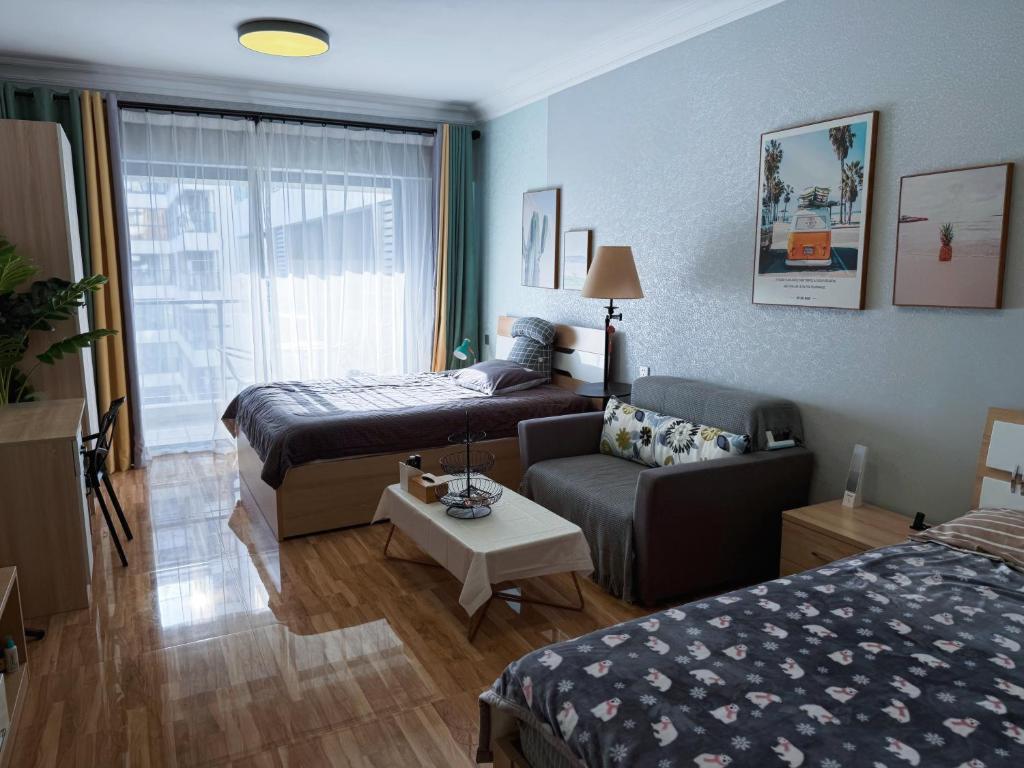een woonkamer met een bed en een bank bij Vanxing Seaside Residence in Huiyangshi