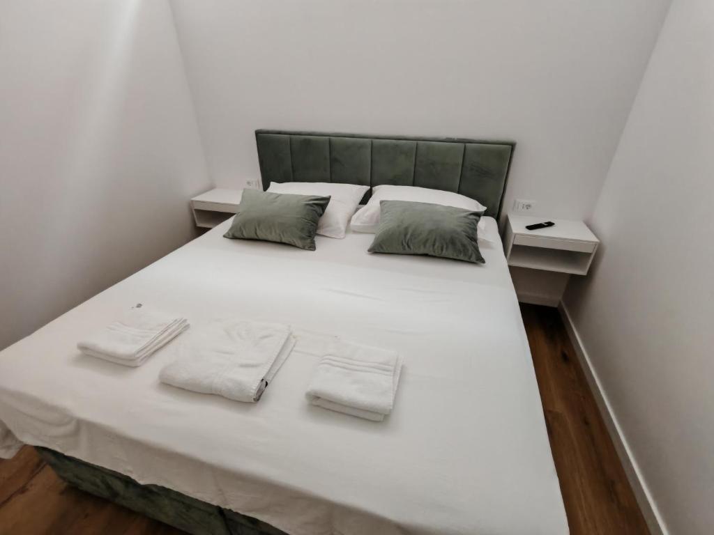 a large bed with white sheets and pillows at The White House Split in Split
