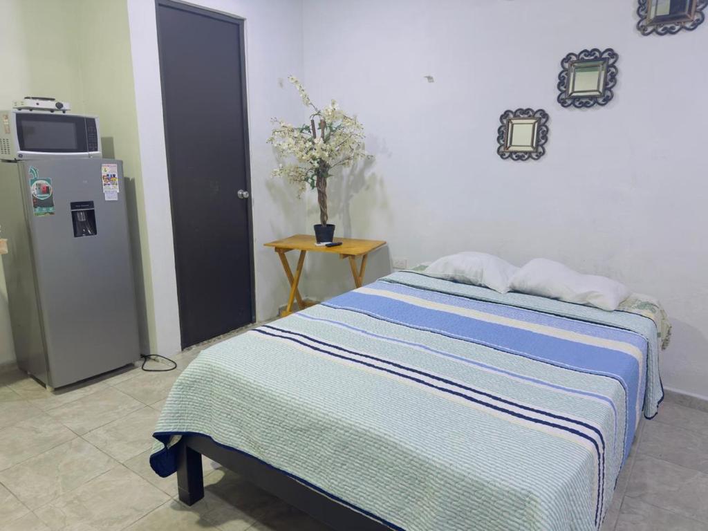 Un dormitorio con una cama y un frigorífico. en departamentos Gina s, en Valladolid