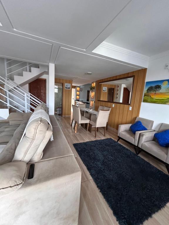 Casa com piscina em Bombinhas في بومبينهاس: غرفة معيشة بها أريكة وطاولة