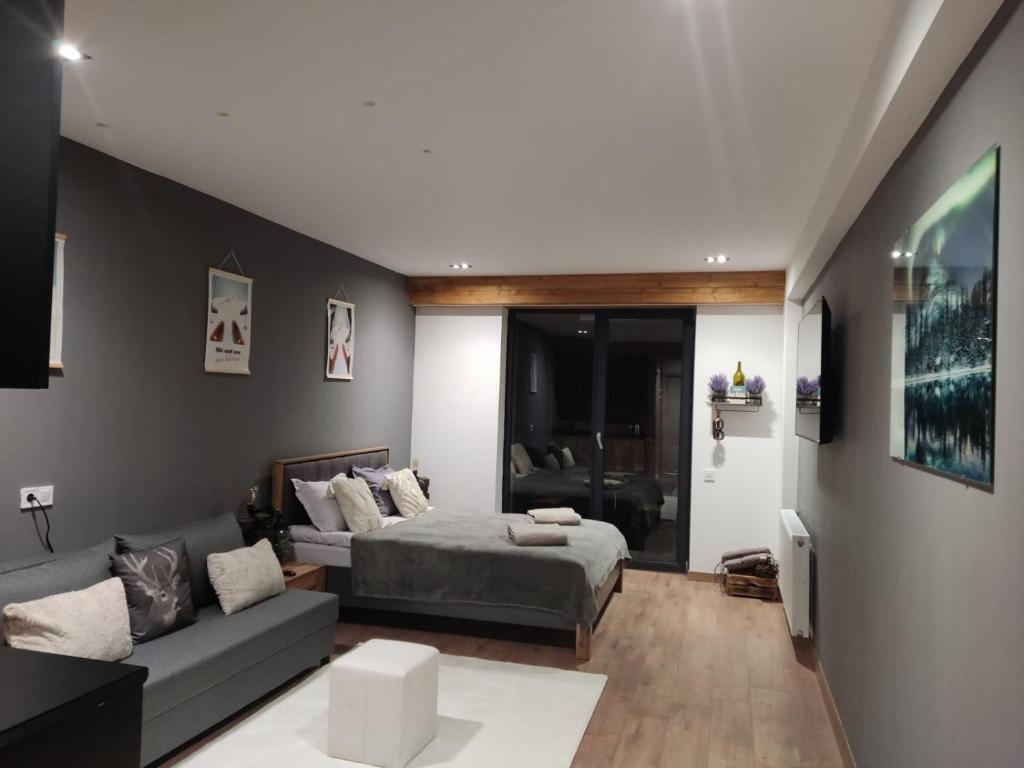 un salon avec un lit et un canapé dans l'établissement Evdo Apartments F4 modern room, à Kʼumlistsʼikhe