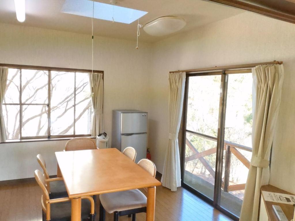 a dining room with a table and chairs and two windows at Tentengo Shibu River - Vacation STAY 79348v in Ono