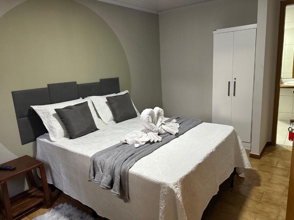een slaapkamer met een groot wit bed met een handdoek erop bij Hostel Lunar in Alto Paraíso de Goiás
