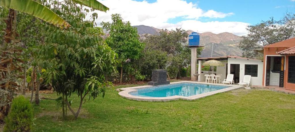 a backyard with a swimming pool with a water fountain at Quinta AM Vacaciones y Turismo in Santa Isabel