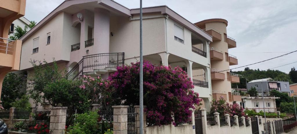 a building with flowers on the side of it at Apartmani Vedrana Sutomore in Sutomore