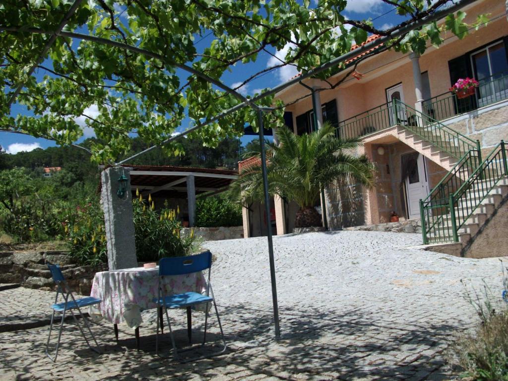 a table and chairs in front of a house at Quinta do Mineiro-Serra da Estrela in Matança