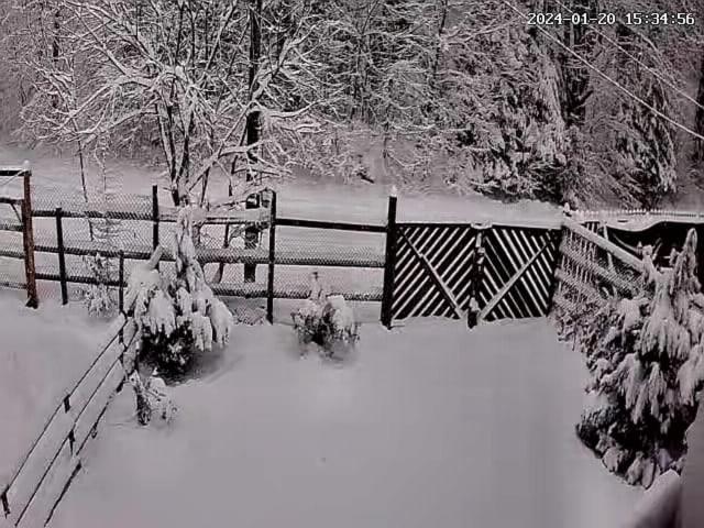a fence covered in snow next to a gate at Casa Munteanu in Porumbacu de Sus