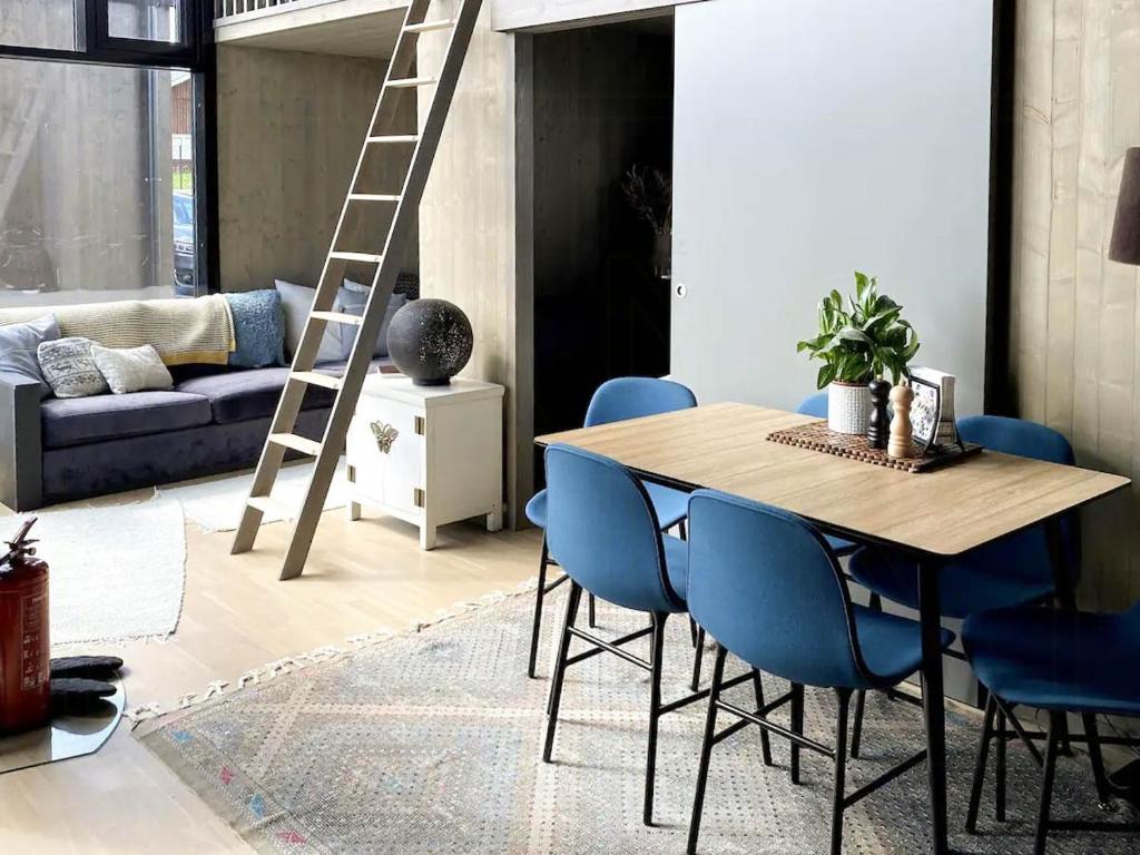 a dining room with a wooden table and blue chairs at Relax In This Cozy Family Cabin 