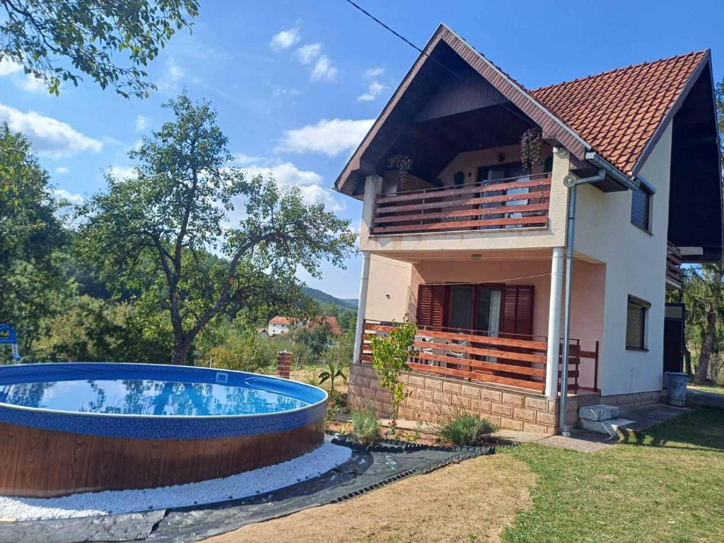 a house with a swimming pool in front of a house at Jankovići Ravni Zlatibor in Zlatibor
