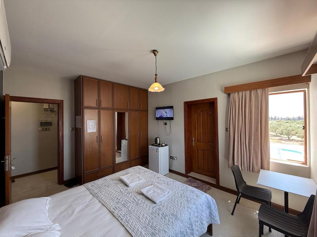 a bedroom with a bed and a desk and a window at Happiness City in Iskele