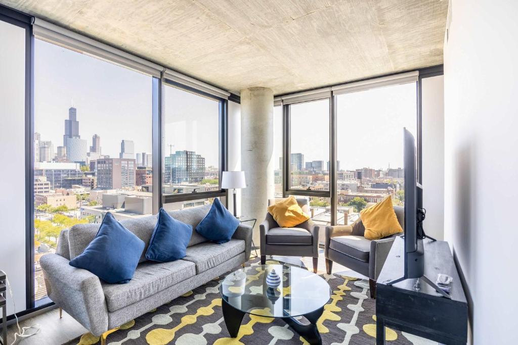 a living room with a couch and some windows at Bright & Modern 2BR Perfect City Escape in Chicago
