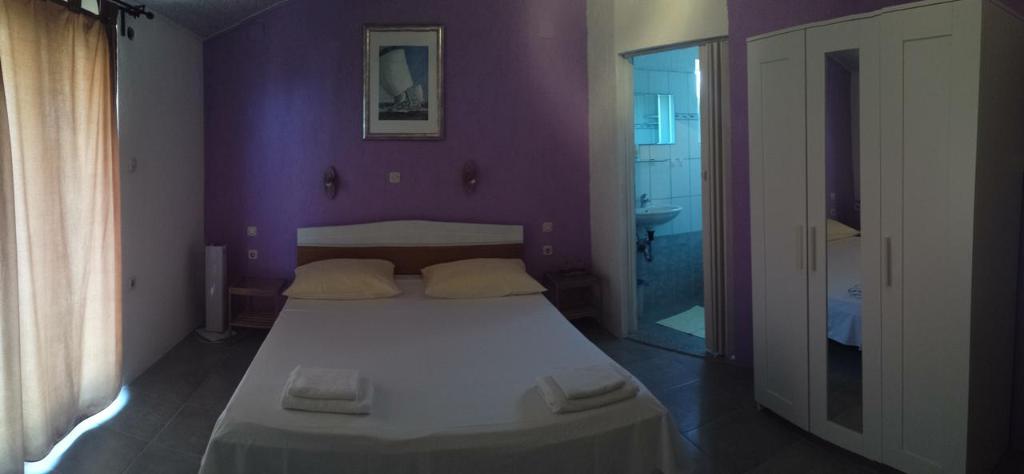 a purple bedroom with a bed and a bathroom at Apartments Antica in Šimuni
