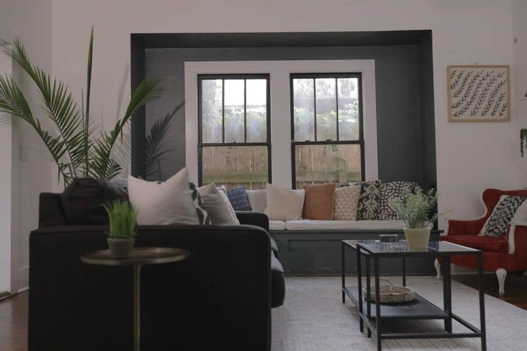 a living room with a couch and two windows at Clinton Street House: Your Lafayette Home Base in Lafayette