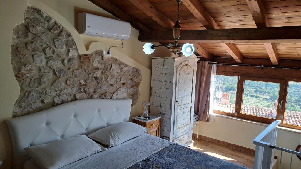 a bedroom with a bed and a stone wall at Silvia House in Prossedi