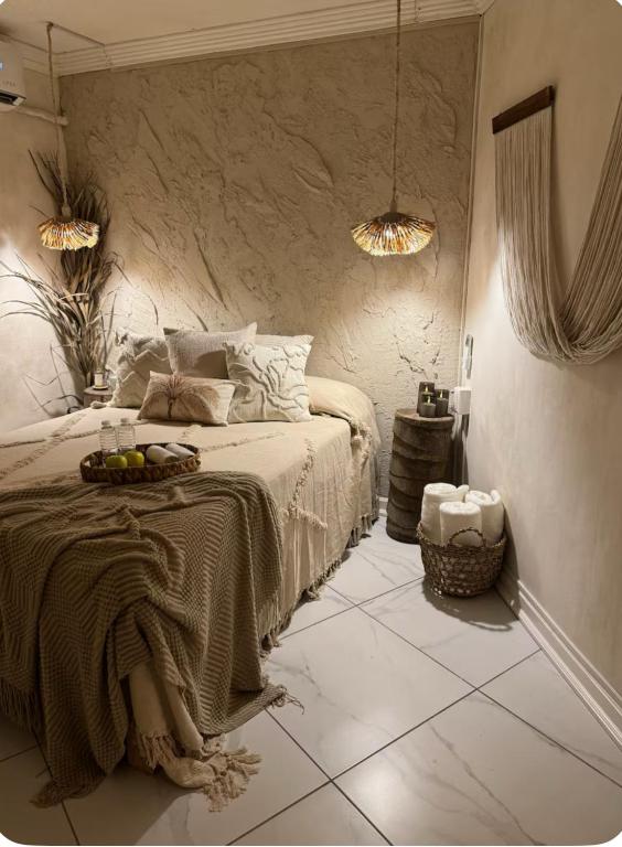 a bedroom with a bed with a table on it at Departamento en Club Santiago - Camina a la playa! in Manzanillo